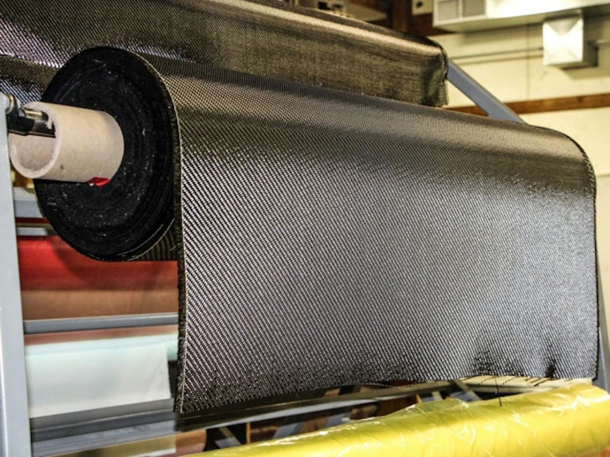 Rolls of raw carbon fiber material waiting to be cut.