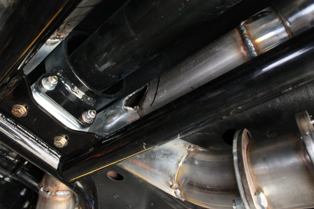 Here, you can  see the hole that we've cut in the pipes to weld the H-pipe into.