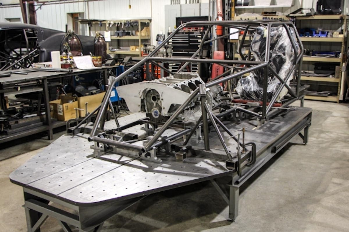 The chassis main structure is complete and the team is ready to start mounting the engine and transmission along with most of the chassis components. A fixture locates the engine and transmission that is keyed to the chassis table, which allows the engine to be mounted on-center without checking it manually. 