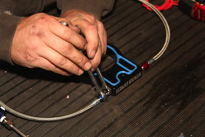 The nitrous and fuel jets, which are precisely calibrated metering orifices, are installed in place between the plate and the stainless steel AN lines that run to the solenoids. Always use a backup wrench on the plate fitting, and don't crank down too hard - these connections take far less torque to properly seal than most people expect.