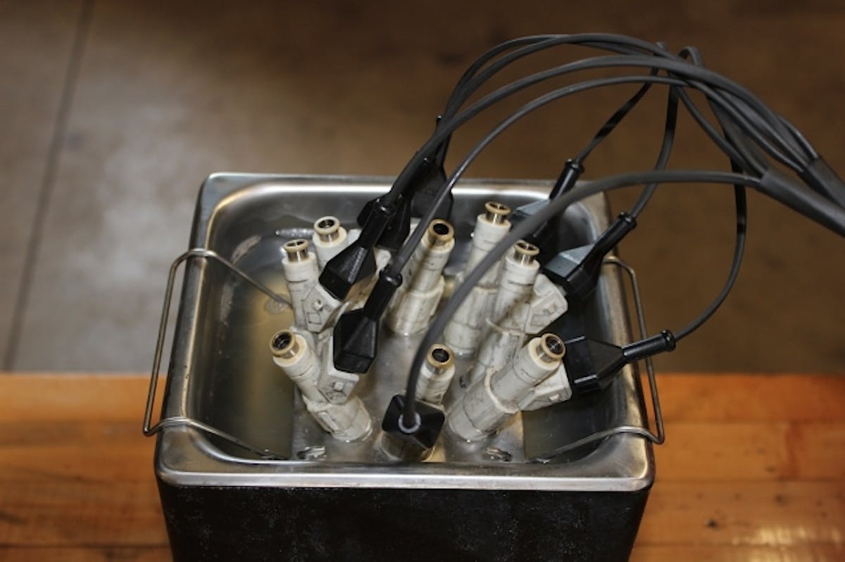 Time for a spa day - the injectors are stripped down and bathe in an ultrasonic cleaner that scrubs them internally with high frequency sound waves while the injector pintles are cycled open and closed.