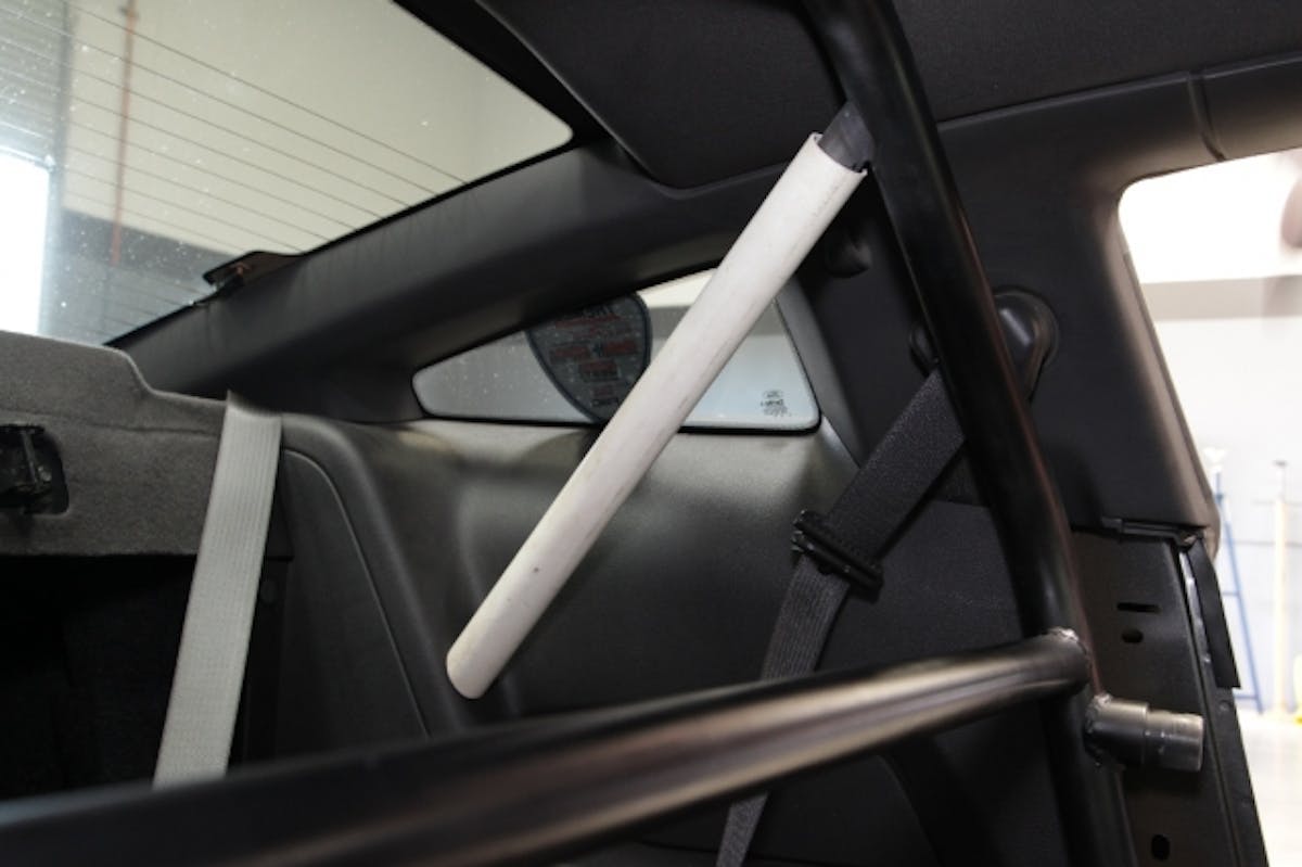 A small section of plastic tubing is placed over the rear support spud to locate the proper placement of the hole in the plastic side panel.