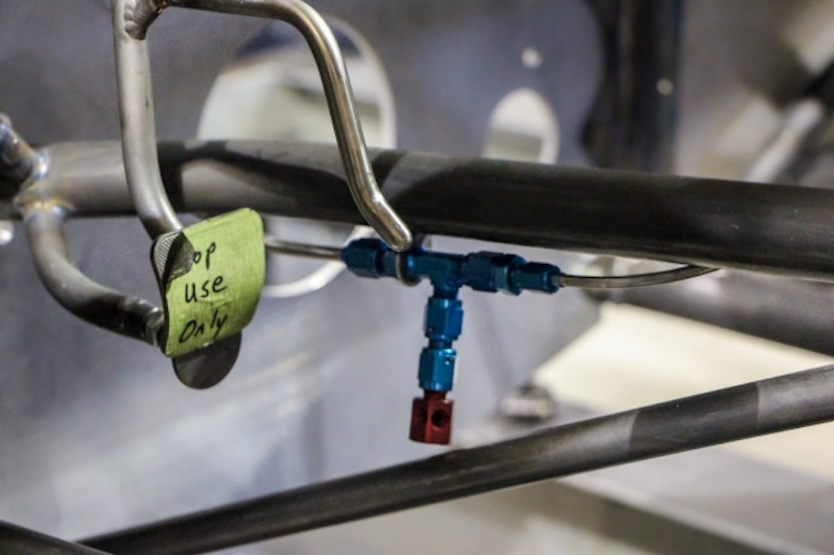 This image shows the fire bottle line and nozzle that will be directed at the driver’s feet and legs.