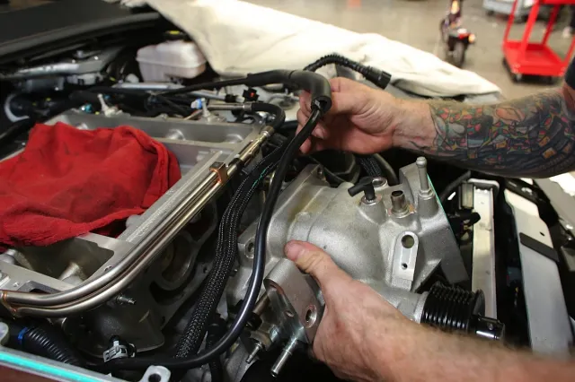 In order to begin the modifications, we needed to remove a number of the stock components to access the supercharger snout. The battery get disconnected and the strut tower bar are removed to begin the process. The airbox, throttle body, and a number of other components come off before you can remove the supercharger cover. Lingenfelter provides incredibly-detailed instructions with the kit.