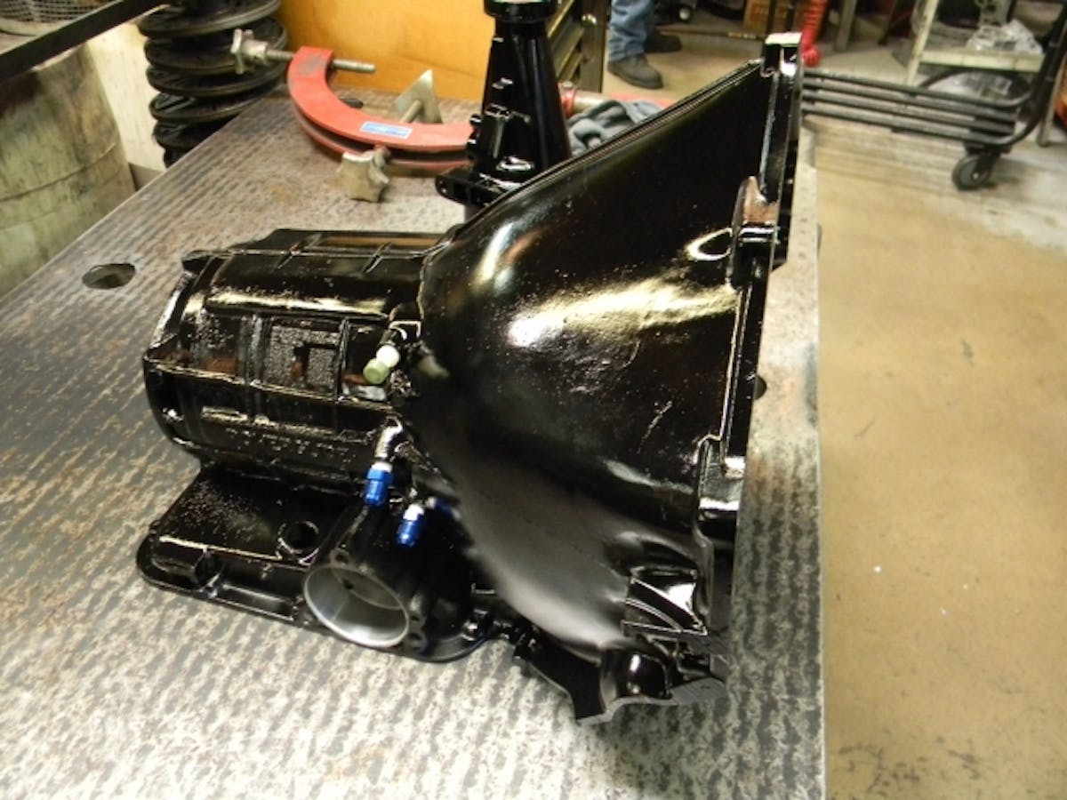 The Powerglide transmission build-up begins with a bare bones, OEM GM Powerglide transmission case. Hughes Performance cleans the cases in a chemical wash, blasts them with baking soda to clean away all the grime, and then paints them with a semi-gloss black paint, before moving on to installing the first components.