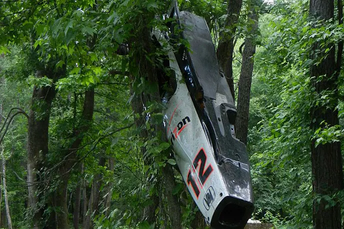 A Will Power Indy car hanging from a tree.