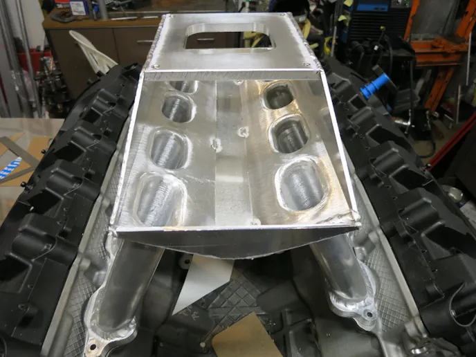 The runner entry points were kept flush to aid the air/fuel entry point into the runner. Using a bellmouth in this instance could have caused fuel suspension issues.