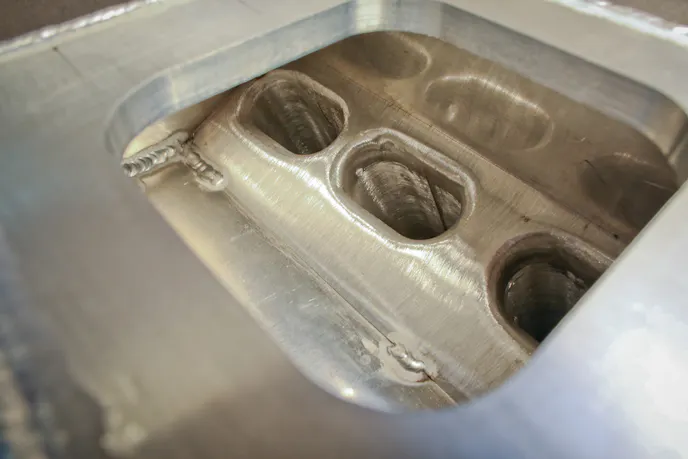 The inside of the plenum - you can see how the plenum floor is tucked up tight to the runner to prevent fuel puddling. Each runner was mocked up by hand prior to final welding. Runners are created from extrusion stock that has been hand-modified to create the final dimensions.