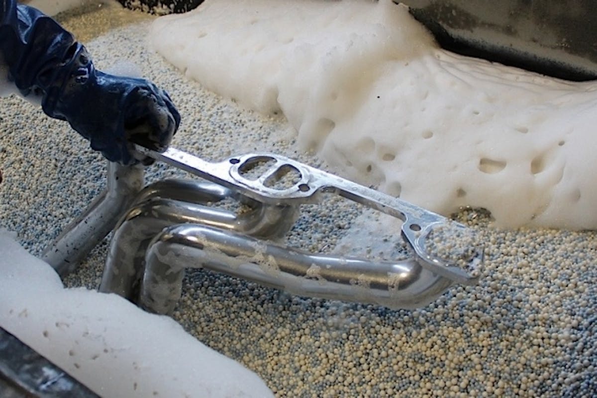 A header in the vibratory polisher after the coating has been applied. See the photo at the top of our headers for an indication of the final results after this step!