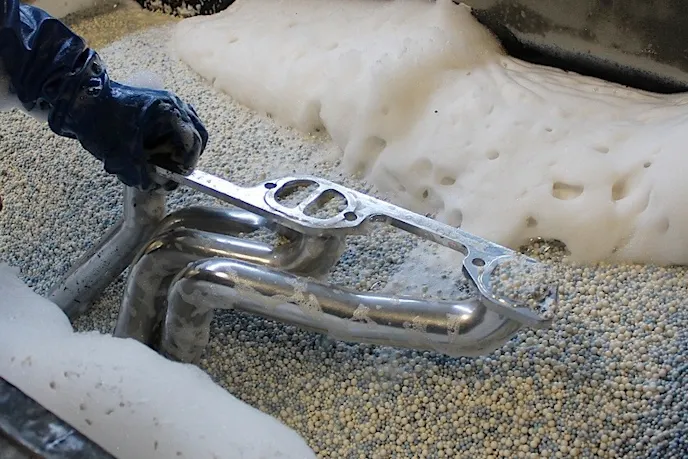 A header in the vibratory polisher after the coating has been applied. See the photo at the top of our headers for an indication of the final results after this step!