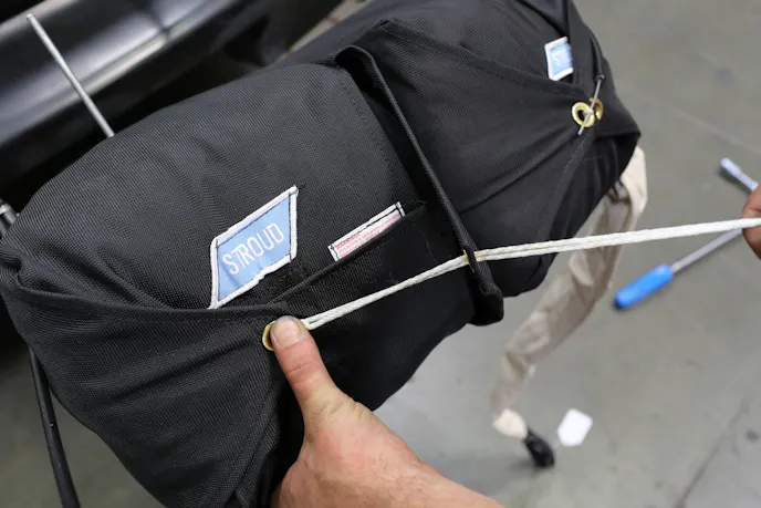 Note when packing the parachute, the flap opposite the flap opposite the ripcord is the last to be loaded into the assembly. This allows the cord to pull against the loop instead of in the same direction.