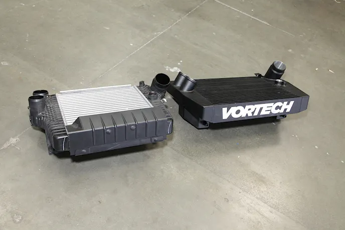 The factory charge air cooler compared to our Vortech piece - as you can see the Vortech item is slightly larger, but all of the factory mounting points remain in place as there is plenty of room behind the bumper to fit the new unit.