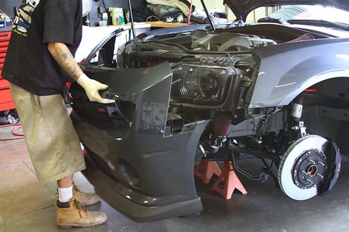 Above: the sidemarker lights are removed from the Camaro. Below: with everything unplugged and unhinged, the stock bumper comes off quite easily.