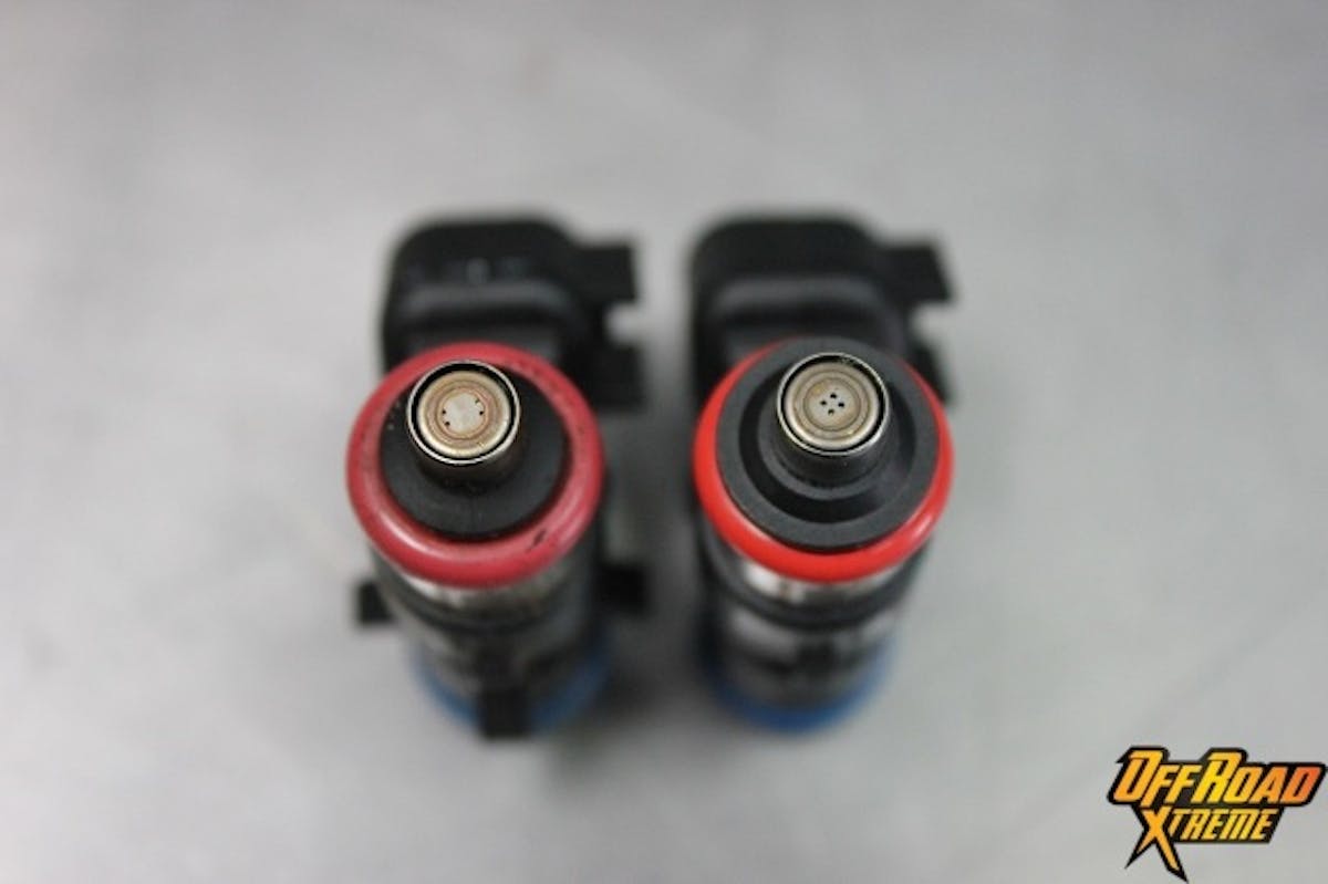 The stock injector (left) is compared with the ProCharger injector (right). Note the grouping of the jets on the ProCharger unit, as well as their slightly larger diameter.