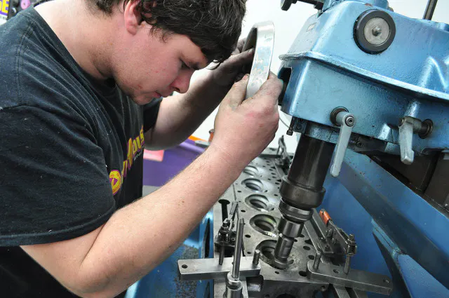 Cutting the new hardened valve seats for unleaded fuel compatibility. A five-angle design was used on the intake side, with four angles directing exhaust flow out of the ports.