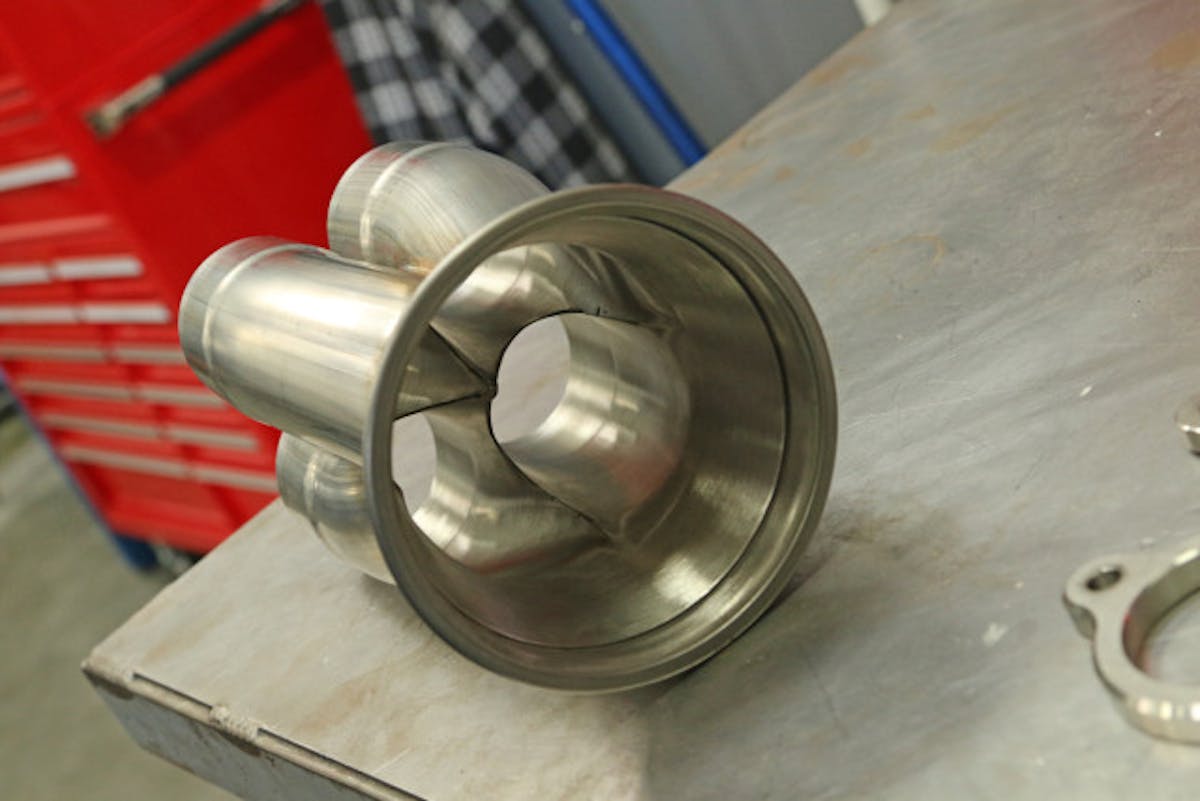 The craftsmanship inside the merge collector is evident in this photo. By putting the spike on the end of the incoming pipes, the collector helps to scavenge the flow from each adjacent pipe as the engine fires in sequence.