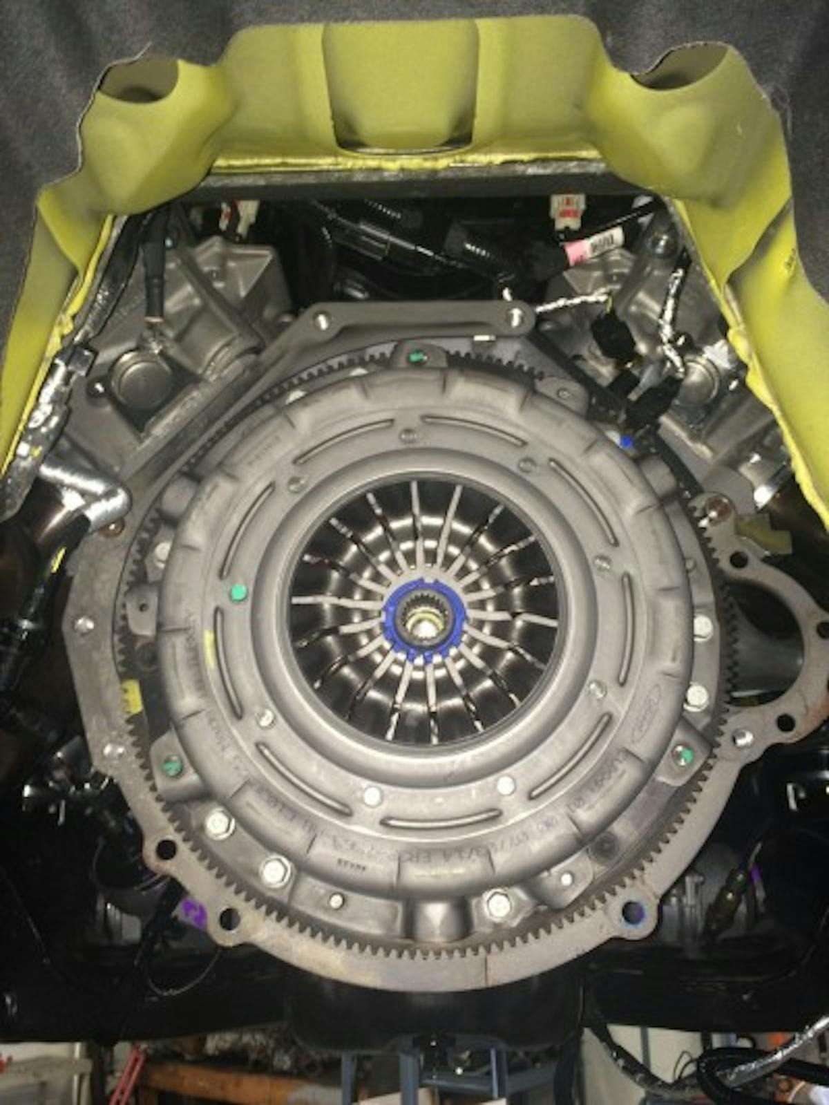 Since the TR-6060 doesn't have a conventional bellhousing, the transmission bolts right to the back of the engine. With the shifter disconnected, loosen the bolts, and use a transmission jack to lower the factory MT-82 out of the tunnel.