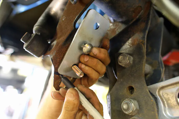Brandon installing the sway-bar relocation kit. This only took about half an hour to accomplish, although we did have the benefit of a lift and air tools.