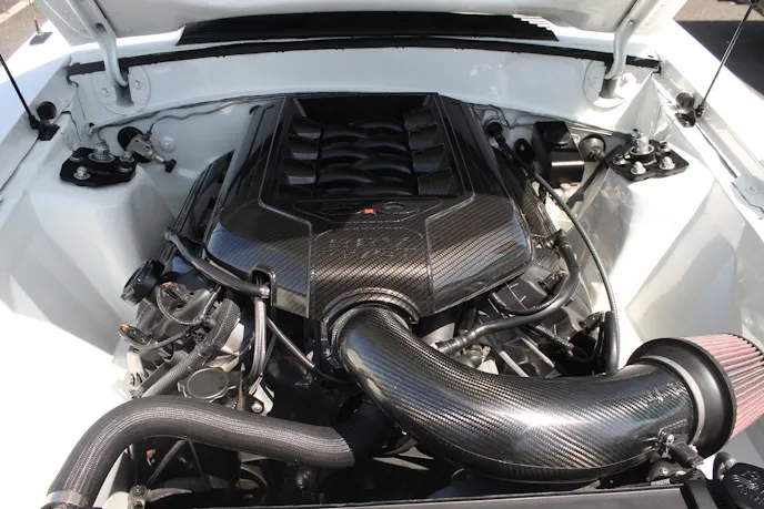 The engine is dressed up with a carbon fiber engine cover and coil covers, while the engine compartment is smoothed out thanks to ScotRod panels.