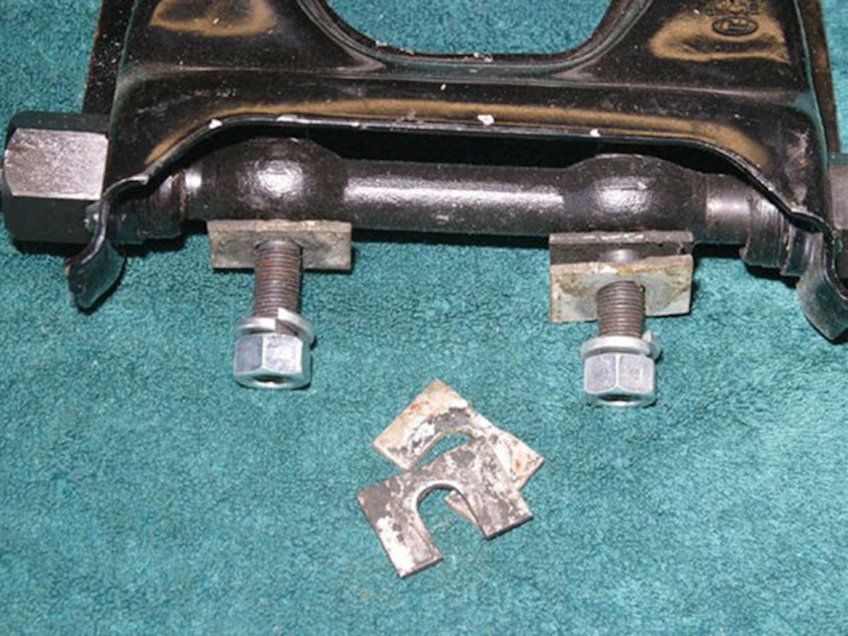 An example on an outboard-mounted upper control arm showing the shims used to adjust caster and camber. When two shims of the same thickness are installed or removed, camber is adjusted. If the shims are of different thicknesses, both caster and camber will be affected. Image by author.