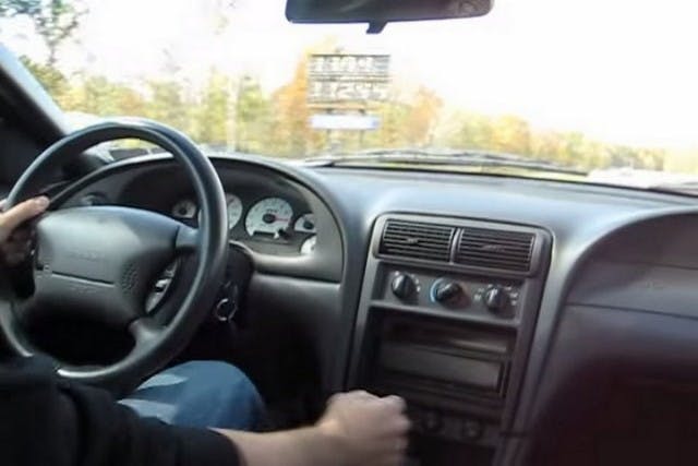 This Cobra seems to have a smaller blower pulley, an aftermarket shifter, and street tires. The car spins at the top of first gear, and all the way through second, so the driver short-shifts into third gear. When trying to hit fourth gear it seems the transmission doesn't want to go in gear. We think by then the throttle is stuck, which causes the missed shift. Factory T56s won't shift at 7,000 rpm. Had this car had a Tremec Magnum, the transmission probably would've gone into fourth, but then what. It's probably a good thing the throttle stuck when it did since the driver had plenty of room to bring the car to a stop.