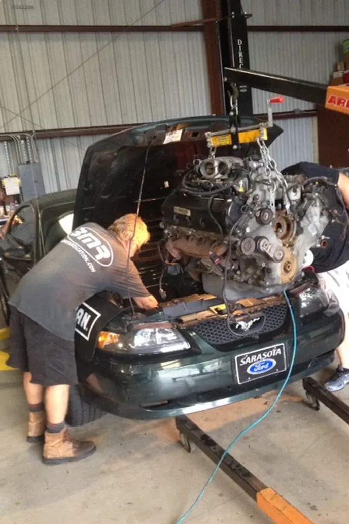 Here we're about to drop the fully-operational engine into place. The engine we're putting in the car is from another Bullitt, and is largely a plug-and-play scenario. We had to clean a lot of the existing parts that had to go back in the car, which added a lot of time to the swap.