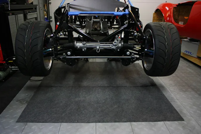 Shown here is the perfect example of how to use Jegs' Garage Mat. The mat goes under your car, and serves as a comfortable area to work on your car, and also soaks up those pesky little leaks our Mustangs are known for.