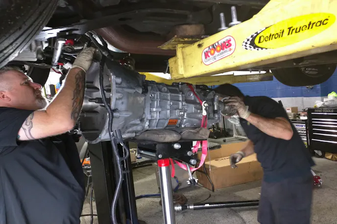 First things first, the factory Tremec TR-6060 transmission has to be removed from the engine to access the clutch. The driveshaft, fluid lines, transmission mount, and shifter must be loosened in order to remove the transmission.