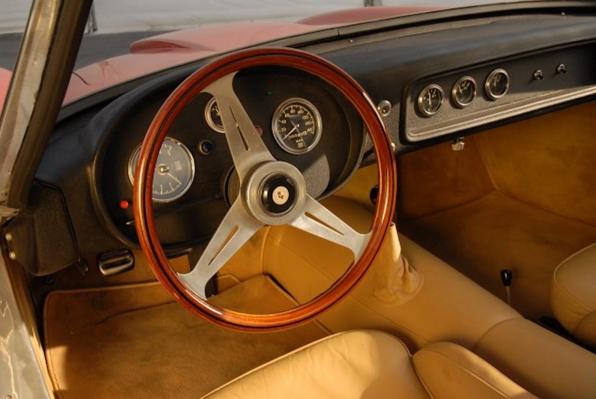 No large center console on this Corvette. Just a wooden-rim Nardi and a crackle-finish metal dash with Stewart Warner gauges.