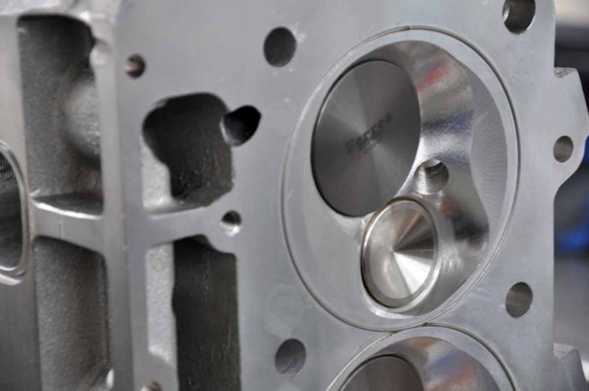 The combustion chamber softening can be seen here; it's the shallow hemispherical cut from the outer edges of the bore towards the combustion chamber's roof. Titanium Ferrea intake and exhaust valves