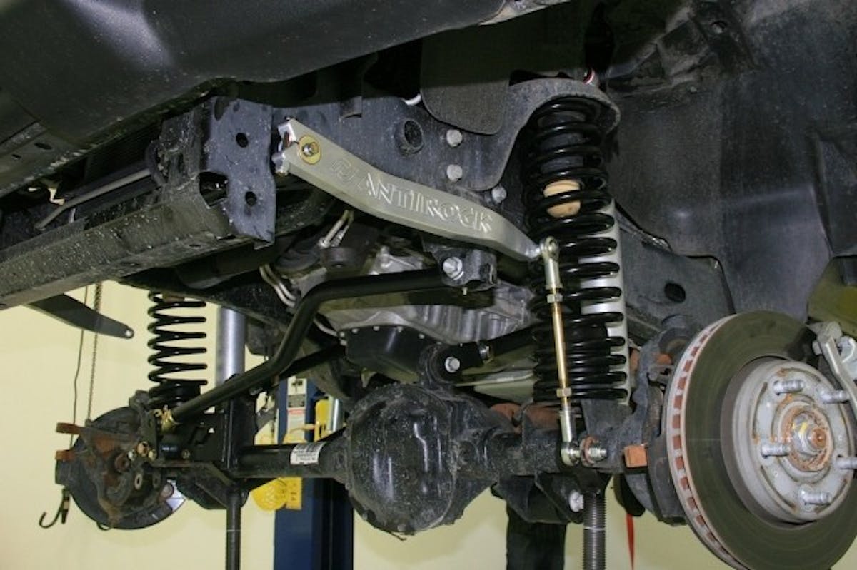 The front Currie Antirock Sway Bar mounts were fastened in position (top left), the torsion bar was slid through them and the arms installed (top right). The links were attached to arms and axles (bottom).