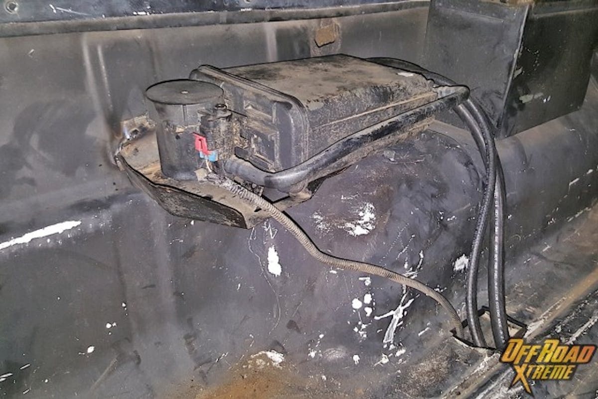 Longer hose and a quick weld made sure that it was not going to be going anywhere. With the canister removed the tire could clear in its new home. To keep the tire from getting cut up against the metal, we finished the hole off with some plastic pinch molding. All that is left now is to add a tire mount to secure the tire and keep it from moving.