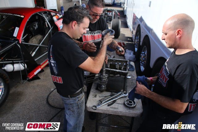 This is what it takes between rounds when you're crewing on the world's quickest four-cylinder drag car. The Napierville Dragway-sponsored machine is driven by Carl Brunet and has been 6.29 at 222 in the quarter mile; he's 9th onthe Outlaw Radial eighth-mile qualifying sheet with a 4.18 -- from only 132 cubic inches of Ecotec Chevy engine, and ahead of some very well-known names in the class. We popped by when they were in the middle of swapping out transmission gears, as a result of swapping rearend ratios. Looks like a fun job, doesn't it?