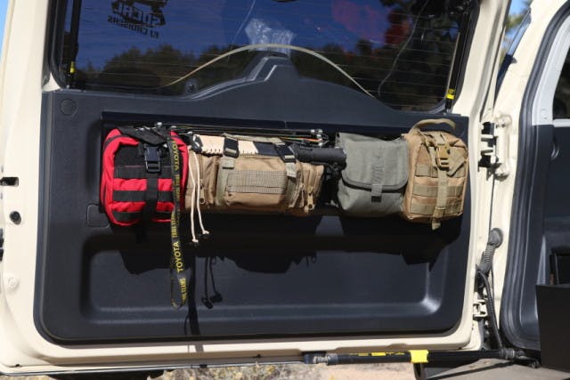 Storage bags attached to the rear tailgate hold a first-aid kit, machete, spare parts and tools at easy reach.