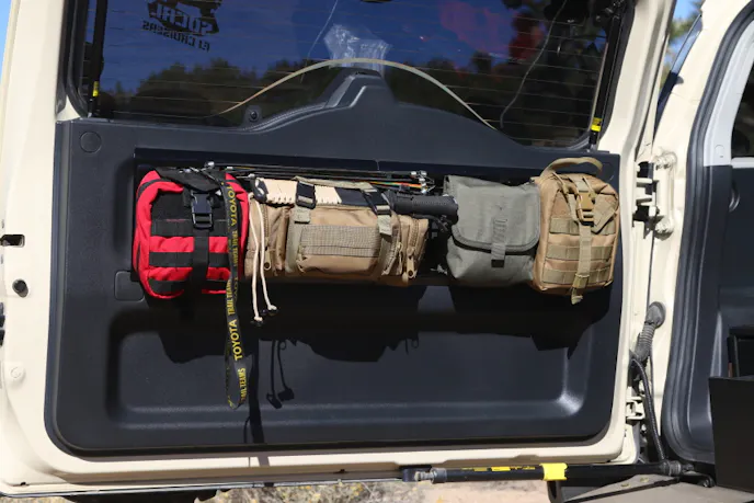 Storage bags attached to the rear tailgate hold a first-aid kit, machete, spare parts and tools at easy reach.