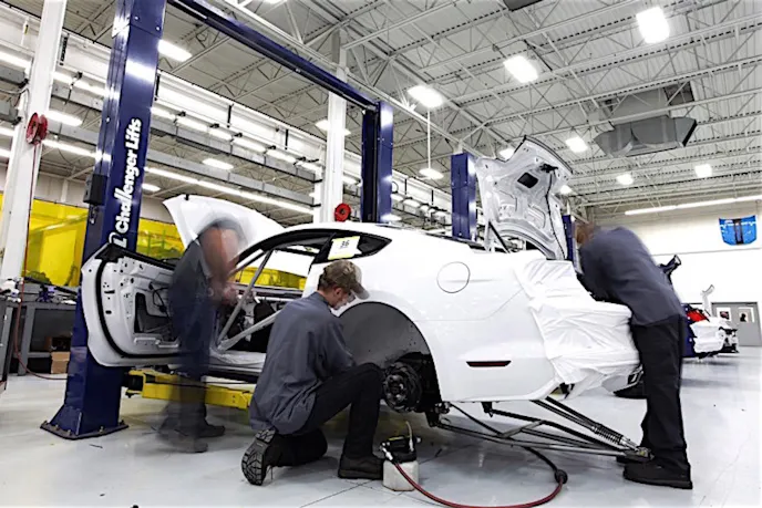 Technicians installing many components by hand on the all-new Cobra Jet at the FRAP.