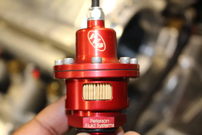 This little gadget is Peterson's open element vacuum regulator. It is installed in an open portion of the crankcase like a lifter valley or valve cover. The set screw allows us to control how many inches of vacuum are created until a check valve opens to relieve pressure.