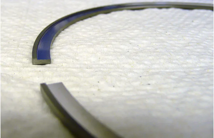 The main purpose of a piston ring is to provide a complete seal in the cylinder and keep the air/fuel mixture in the combustion chamber for full burn. There are several leak paths in a standard piston ring setup. The ring gap (left) is one such path. Total Seal offers a gapless style ring (right) to prevent combustion leakage through the standard ring gap. Our C33 stainless steel top ring in a .017-inch Dykes configuration. Total Seal takes a standard 1/16-inch ring (.0625-inch thick) and then machines a .017-inch step from the inside of it to form a sideways “L” shape. They also reduce the radial thickness to .175-inch.