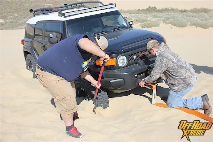 Getting someone unburied from the sand is a team effort.