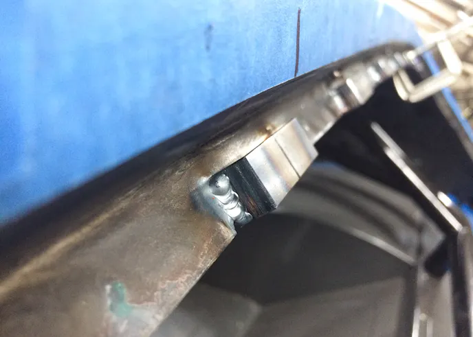 A close-up of the mounting blocks we welded to the body flange. On the front windshield, these ranged in spacing from 4.5 to 6 inches. Optic Armor advises 4-inch spacing, but because we were doubling-up with weatherstripping, we could get away with slightly wider-spaced bolts and maintain integrity.