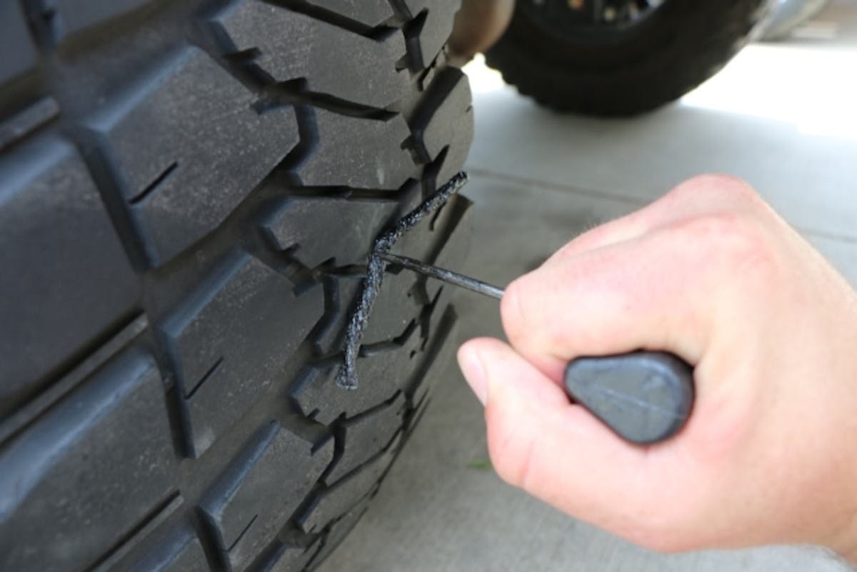 Dab a bit of rubber cement on the end and push the tool through the hole in the tire. This usually takes a fair amount of force but be careful not to push all the way through. Ask me how I know.