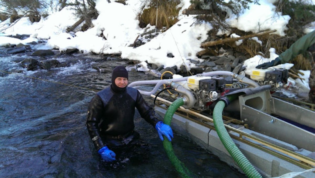 Kris' vocation is as a dredge miner. His workday consists of suiting up in a drysuit and lead weights, staying on the bottom of a freezing cold riverbed for hours, and working a suction hose back and forth in search of gold.
