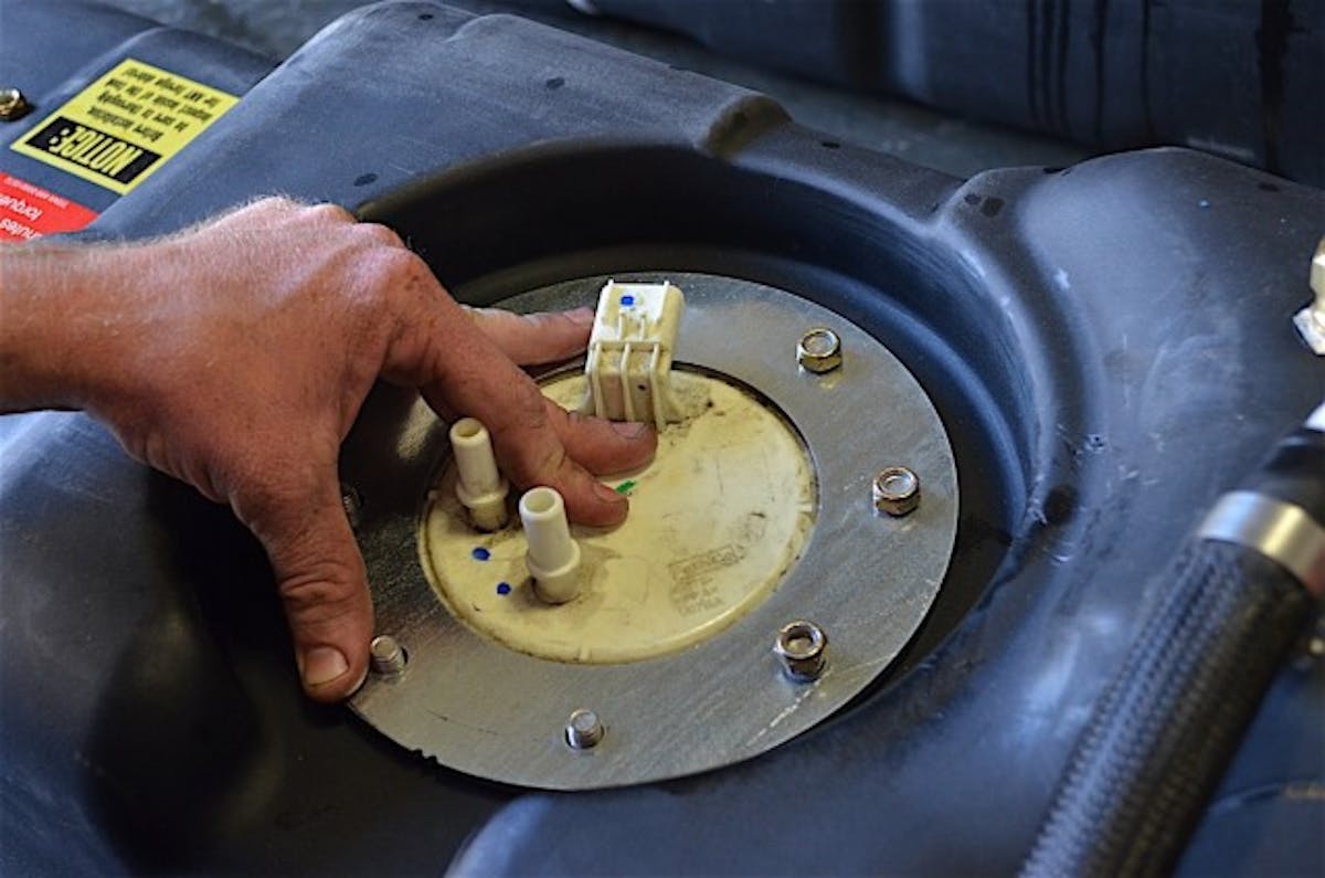 The fuel pump is inserted into the hole and clamped down with the flange's eight nuts.