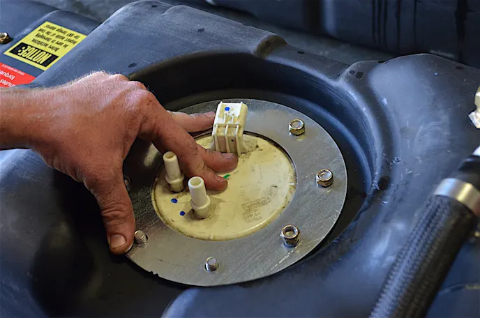 The fuel pump is inserted into the hole and clamped down with the flange's eight nuts.