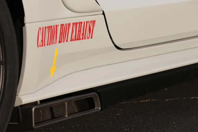 The aforementioned exhaust not only delivers an aggressive sound, but enough flow to support over 850 horsepower. Better yet it does so through high-flow cats and mufflers that exit at these stylish tips in front of the rear wheel well. Like all the other art on this car, the hot exhaust warning is painted on. There are no vinyl decals on the VMP Mustang.