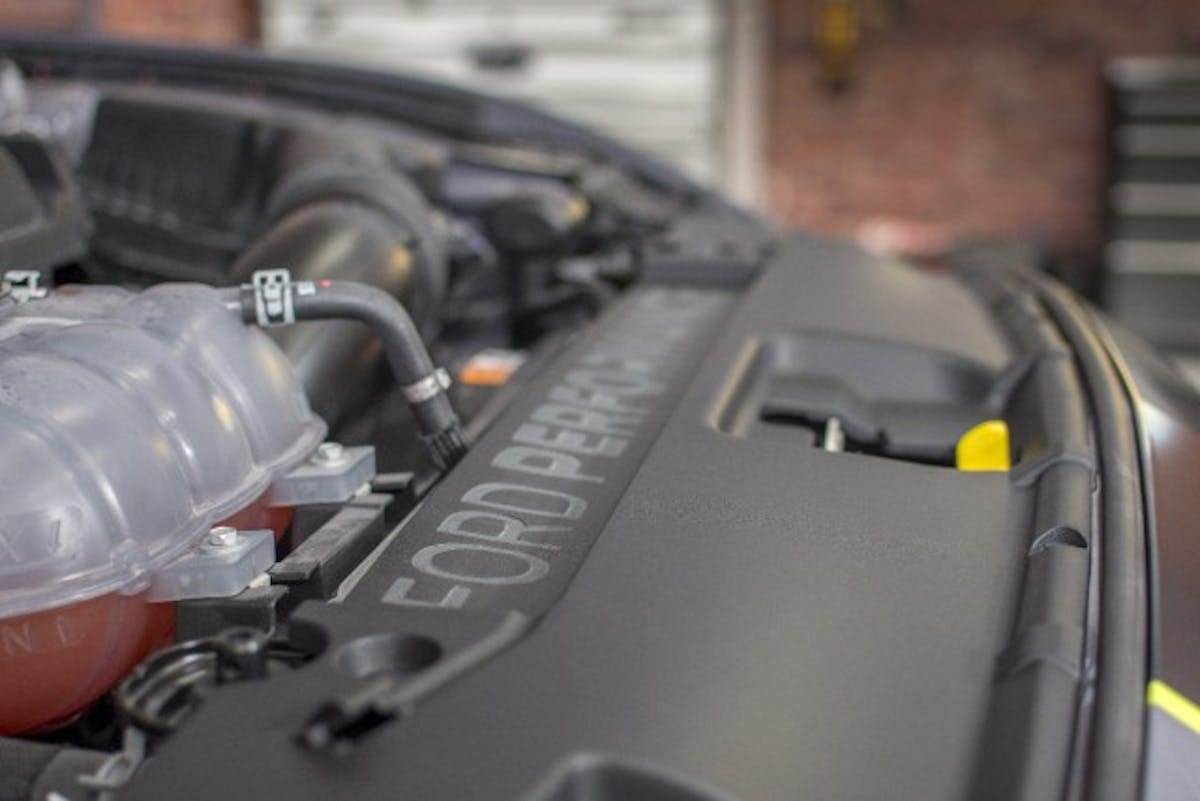 Pop the hood and a host of Ford Performance Parts upgrades raise the performance level of the stock 2.3-liter engine. The cold air intake, strut tower brace and touring Cat-Back exhaust are all from the pages of the FPP catalog, while a Cobb Tuning downpipe and intercooler at a little extra oomph. All of the mods play well together thanks to a Ford Performance calibration delivered via a ProCal tuner. (Photo Credit: CJ Pony Parts)