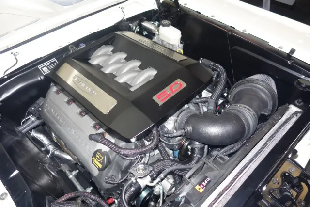 The TCI 1964.5-1970 Ford Mustang Custom IFS deletes the shock towers, which helps Revology swap in a modern Coyote powerplant, which is a swap they have perfected with a number of custom parts.