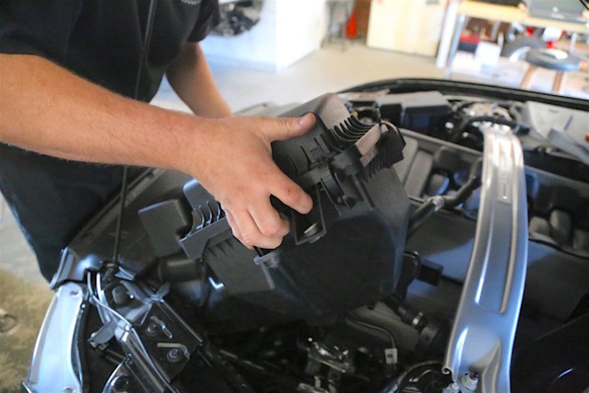 Steven removes then loosens the inlet tube clamps and unbolts the airbox so that he can remove the factory induction system in one piece.