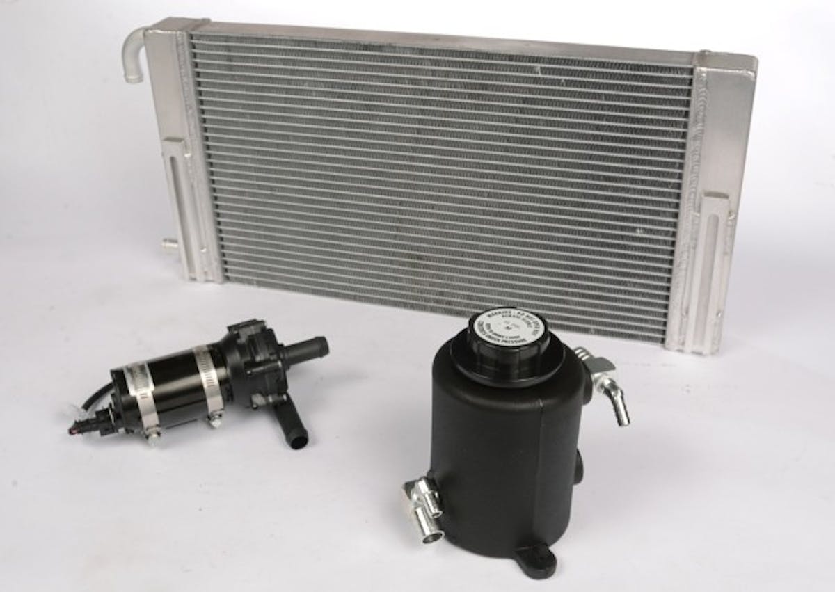 Kenne Bell superchargers use water-to-air charge cooling so the usual two heat exchangers, pump and reservoir are required—plus a few more nuts and bolts we elected not to clutter the photo with. This radiator mounts behind the bumper; the other heat exchanger is in the intake manifold. 