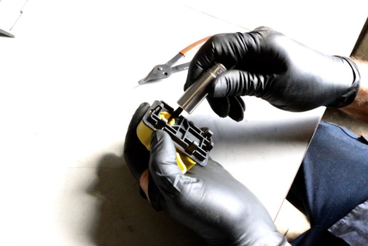 Using a ½-inch socket, Steve depreses the clips holding the factory lever in its bracket.